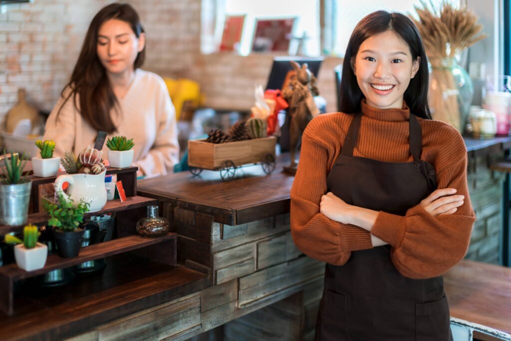 beautiful-attractive-asian-cafe-shop-owner-smile-with-happiness-joyful-with-coffee-cup-apron-cafe-background